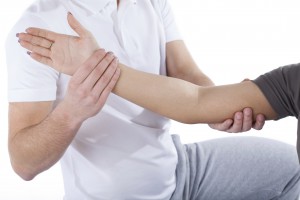 Physiotherapy doctor examining woman's elbow