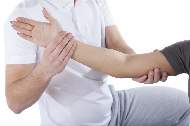 Physiotherapy doctor examining woman's elbow