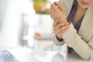 closeup on business woman with wrist pain